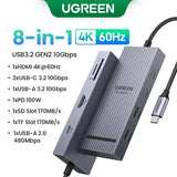 UGREEN USB-C Hub with 4K Video Ethernet and 10Gbps Data surrounded by various cables and connectors.